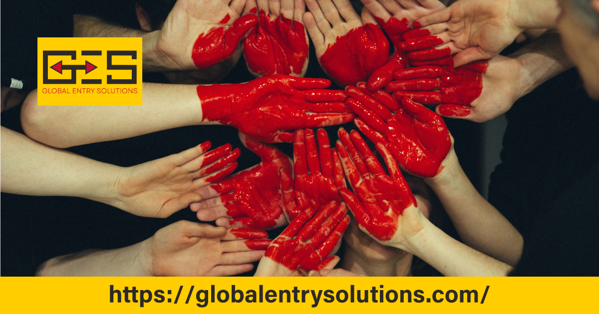 Multiple hands painted red forming a heart shape symbolizing teamwork and social inclusion